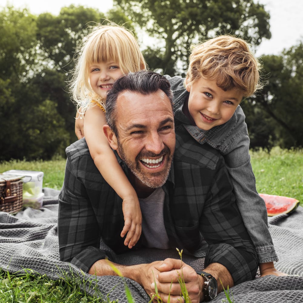 A asian mother and two children are laughing and snuggling.